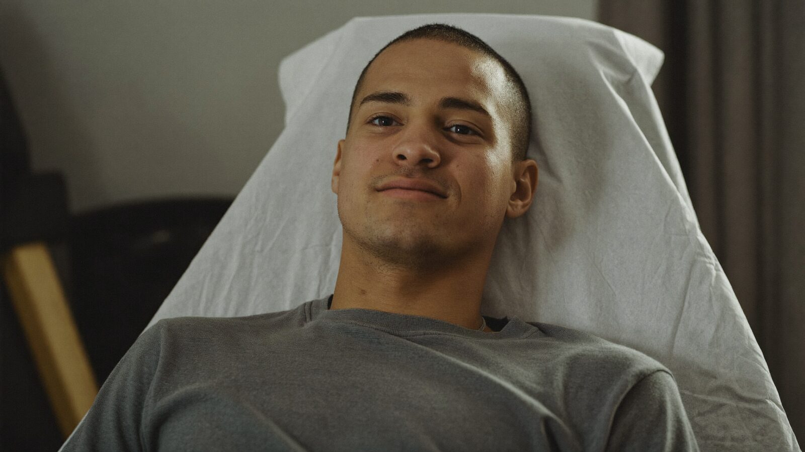 Man with a short haircut resting in a reclined treatment chair