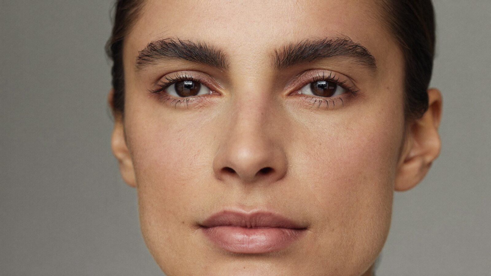 Close portrait of a woman with full, natural, well-shaped eyebrows